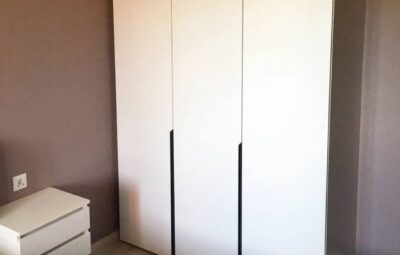Белый шкаф с подвесными тумбами в спальню