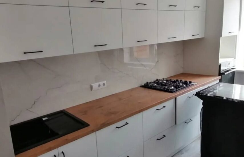 Белая кухня со столешницей цвета натурального дерева и черные ручки